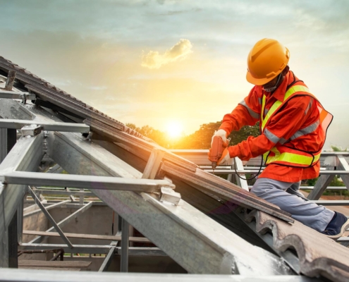 Worker Drilling On New Roof Tiles