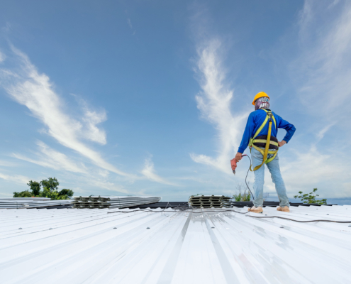 A Roofer Using Electric Drill Nail Gun Installing Pu Foam Roof Sheet At Under Construction