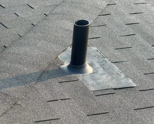 Close-up of metal roof flashing installed around a commercial HVAC unit penetration on a flat roof