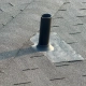 Close-up of metal roof flashing installed around a commercial HVAC unit penetration on a flat roof